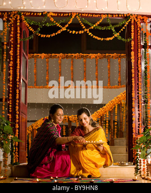 Mère et fille avec un plateau de diyas Banque D'Images