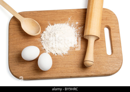 Les oeufs et la farine sur une planche en bois Banque D'Images