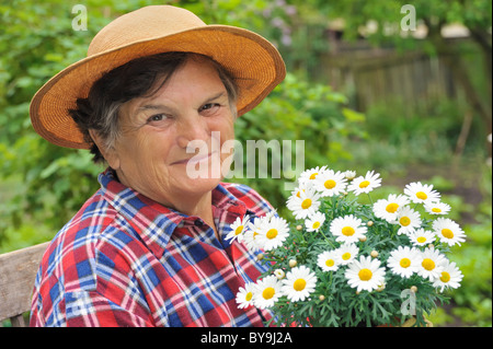 Senior woman gardening - fleurs en pot - Begonia Banque D'Images