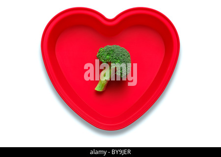 Photo conceptuelle de brocolis dans un plat en forme de coeur pour représenter un amour de la légume, isolé sur fond blanc Banque D'Images