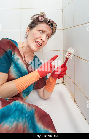 Funny femme parlant à brosse en douche sale Banque D'Images