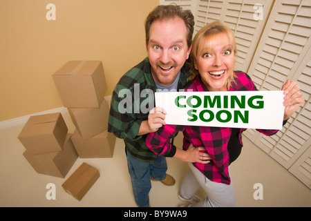 Goofy Couple Holding a venir signer dans la chambre avec des paniers boîtes de carton. Banque D'Images