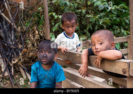 Trois garçons avec des visages sales sont recueillies sur un panier en bois tout en vivant dans la pauvreté, car les enfants de la ferme près de Vang Vieng, Laos. Banque D'Images