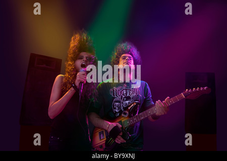 Femme chanter pendant que l'homme joue sur la guitare Banque D'Images