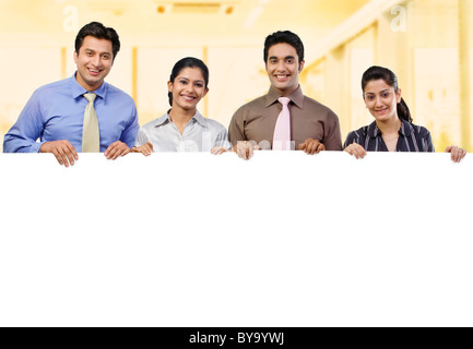 Businesspeople holding a placard Banque D'Images