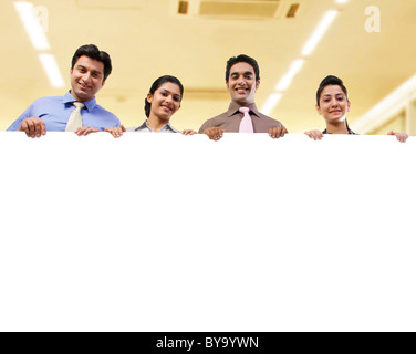 Businesspeople holding a placard Banque D'Images
