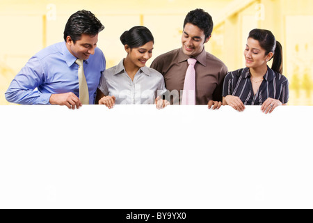 Businesspeople holding a placard Banque D'Images