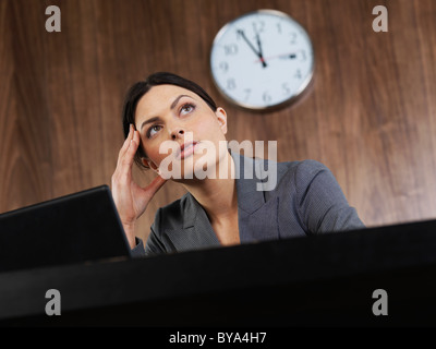 Business Woman sitting at desk vous pensez Banque D'Images