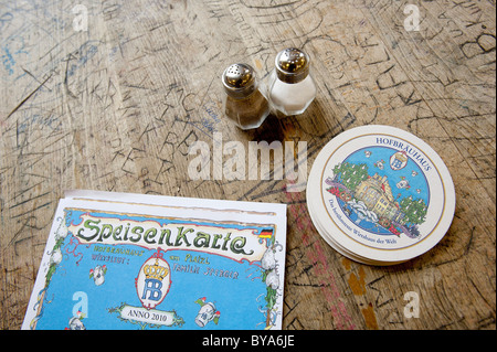 Salières et poivrières, sous-bocks et un menu sur une table dans une bière, Hofbraeuhaus hall, la culture de la bière, Munich, Bavière Banque D'Images