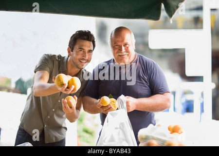 Les hommes de vendre des oranges Banque D'Images