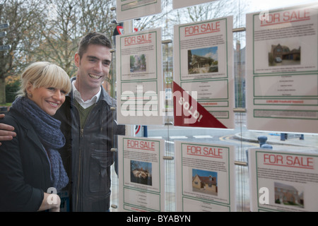 Couple à la fenêtre en agents immobiliers Banque D'Images