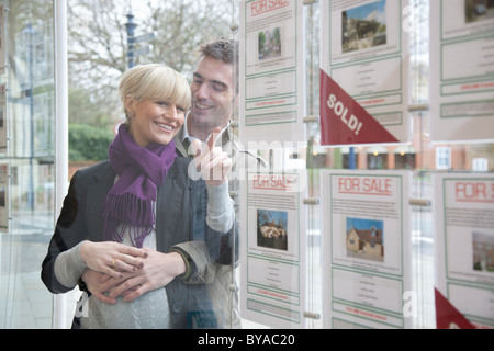 Couple à la fenêtre en agents immobiliers Banque D'Images