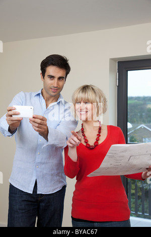 Couple taking photo dans nouvel appartement Banque D'Images