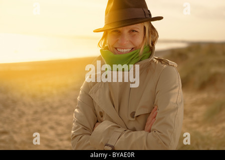 Jeune femme sur la plage de hat et de l'imperméable Banque D'Images