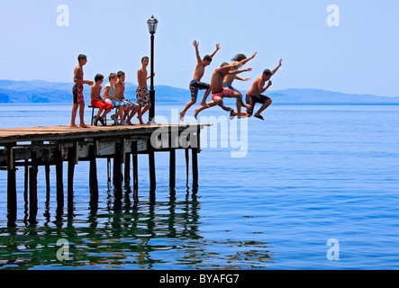 Une bande d'enfants s'amusant sur une chaude journée d'été sur la jetée de la ville de Molyvos, île de Lesvos, Grèce Banque D'Images