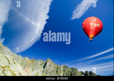 Les nuages de haut niveau au-dessus de l'Aiguille Rouge Parc National près de Chamonix, avec un ballon à air chaud. Banque D'Images
