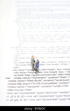 Figurines standing sur le code source d'un site web Banque D'Images