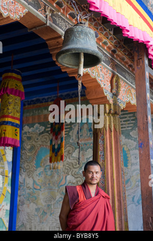 Moine debout sous une cloche dans la forteresse château de Wangdue Phodrang, Bhoutan, Asie Banque D'Images