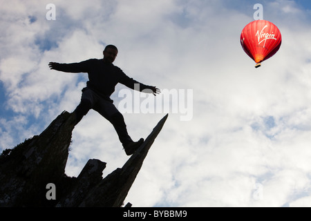 Un homme l'escalade sur le Fleetwith Pike, Lake District, UK, avec un ballon à air chaud. Banque D'Images