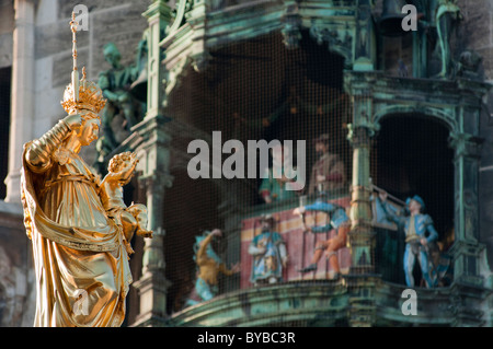 L'or des statues de la Vierge à côté de l'rathuas glockenspiel sur la Marienplatz, Munich, Allemagne Banque D'Images