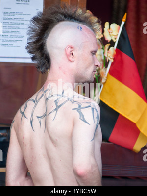 Un 'mohican' Allemand à côté du drapeau national de l'Allemagne. Munich, Allemagne. Banque D'Images