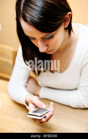 Femme tenant un téléphone portable dans sa main Banque D'Images