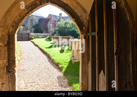 La recherche du chemin cimetière du porche porte de St Michaels church dans le village de Cotswold Stanton, Gloucestershire Banque D'Images