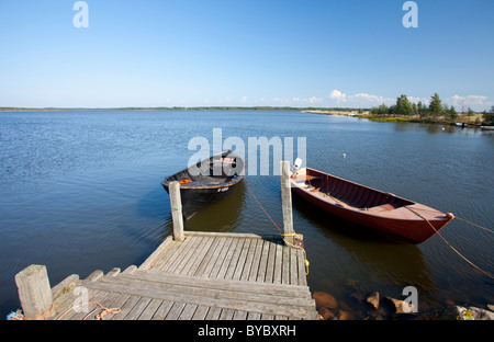 Vieux bateaux de pêche en bois de style traditionnel / skiffs amarrés à une jetée à l'île de Hailuoto, en Finlande Banque D'Images