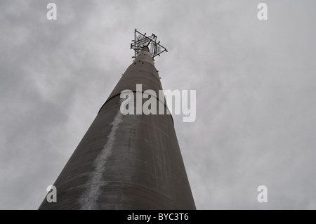 Une communication (téléphone cellulaire), atteignant jusqu'à un ciel nuageux. Banque D'Images