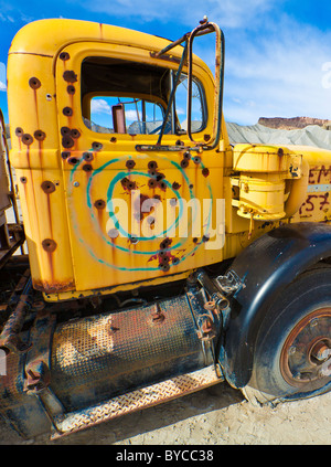 Vieux camion abandonné utilisé comme cible de tir plein de trous de balle. Banque D'Images