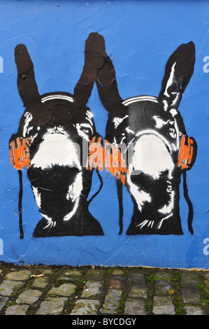 Graffiti pochoir à Bristol en Angleterre illustrant les ânes listening to music on headphones Banque D'Images