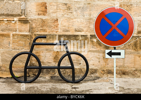 Point de stationnement des vélos. Aucun signe d'arrêt. Flèche vers la gauche. Mellieha, Malte Banque D'Images