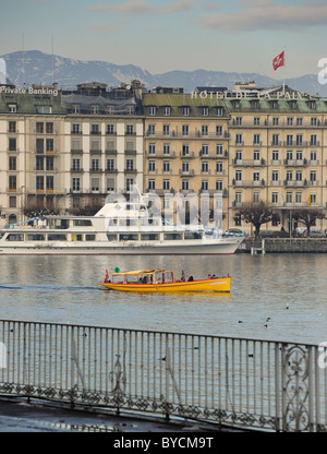 Un ferry jaune dans la ville de Genève au bord de l'eau sur le lac de Genève en Suisse. Banque D'Images