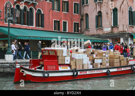 La livraison des marchandises par bateau à Venise, les touristes sur la chaussée Banque D'Images