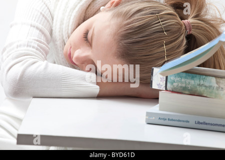 Jeune femme blonde, épuisé à côté d'un ordinateur portable Banque D'Images