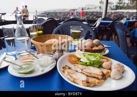 La cuisine espagnole dans le restaurant, le poisson grillé avec pommes de terre des Canaries, Papas arrugadas, Mojo Rojo, source Mojo Verde Banque D'Images