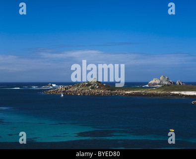 , Îles Scilly Tresco, Royaume-Uni. Afficher le nord du cap Lizard à l'îlot rocheux de Menavaur, avec un kayak et un petit yacht Banque D'Images