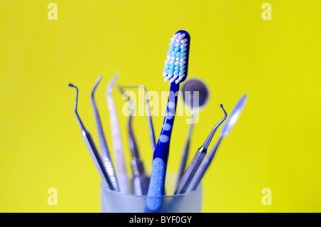 Brosse à dents et des instruments dentaires dans un verre Banque D'Images