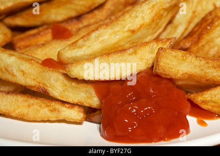 Plaquettes fait maison et sauce tomate ketchup sur une plaque dans le uk Banque D'Images