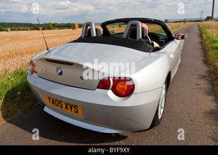 Open top argent métallique BMW Z4 personal luxury arrière arrière voiture de sport sur la route de campagne anglaise. JMH4858 Banque D'Images