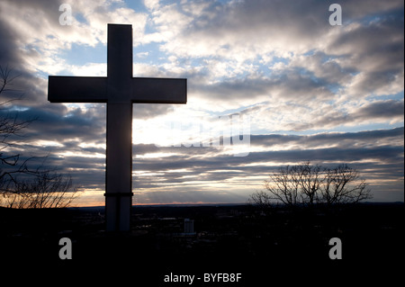 Une croix est découpé sur les nuages et le soleil couchant. Banque D'Images