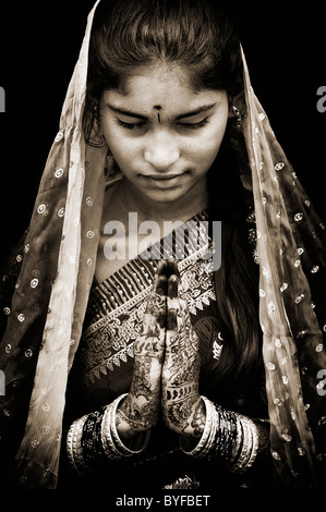 Indian girl wearing silk sari traditionnel au henné la prière les mains. L'Andhra Pradesh, Inde. Sépia Banque D'Images