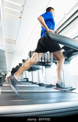 Man running on treadmill in gym Banque D'Images