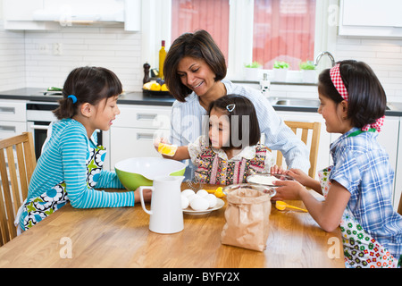 La mère avec les filles dans la cuisine Banque D'Images