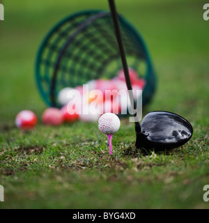 Balle de Golf sur tee à côté golf club Banque D'Images