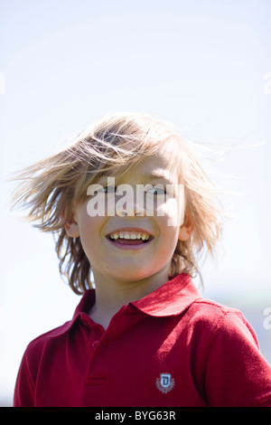 Boy blowing dandelion en plein soleil Banque D'Images