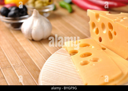 Fromage Emmental ou maasdam avec des légumes sur la table Banque D'Images