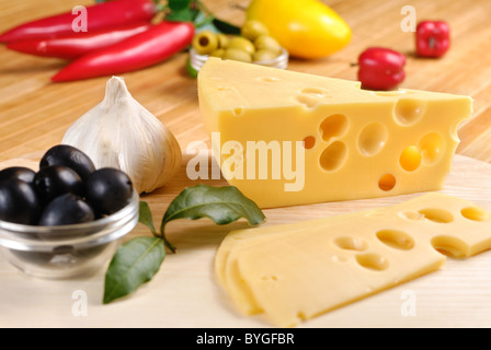 L'emmental avec des légumes sur la planche à découper Banque D'Images