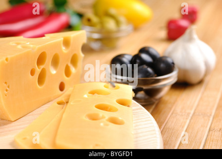 Fromage Emmental ou maasdam avec des légumes sur la table Banque D'Images