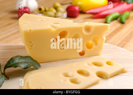 L'emmental avec des légumes sur la planche à découper Banque D'Images